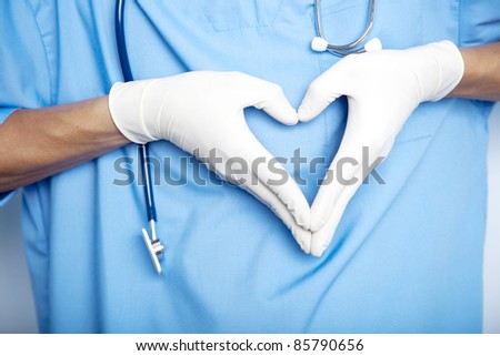 Doctor hands in gloves in the shape against the background of his body. closeup