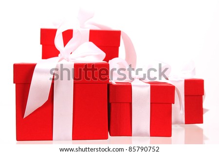 Red gifts tied with a white satin ribbon bow.