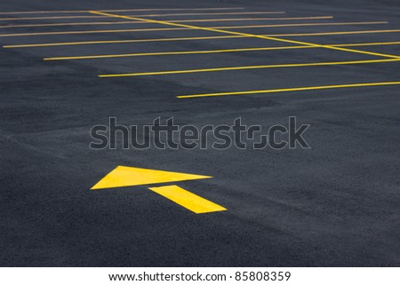 Directional yellow arrow symbol in a typical parking field