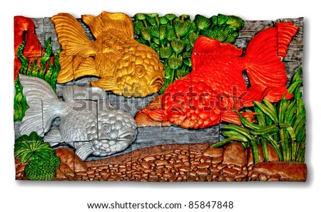 The Relief carving sandstone of goldfish isolated on white background. This is traditional and generic style in Thailand. No any trademark or restrict matter in this photo.