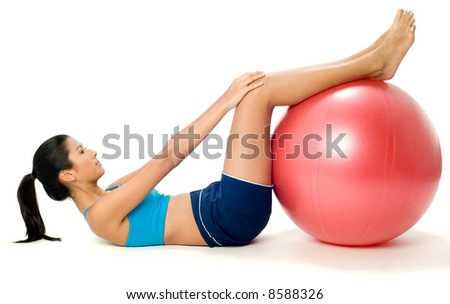 A pretty young slim Asian woman exercising with a red fitball