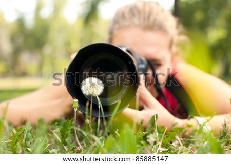 photographer - girl making pictures of flower in nature