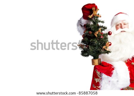 Christmas theme: Santa Claus holding christmas tree and his bag full of gifts over white background