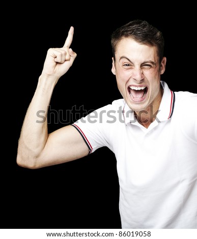portrait of young man laughing and pointing up over black background