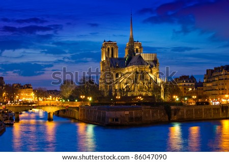 Stunning Notre-Dame Cathedral (1163) and Parisian apartments along the banks of the river Seine, Paris, France illuminated at night. Royalty-Free Stock Photo #86047090