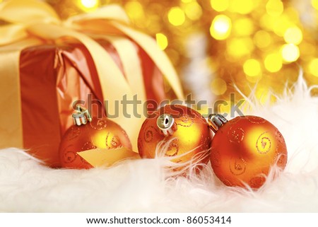 golden christmas ball and gift on a furry background