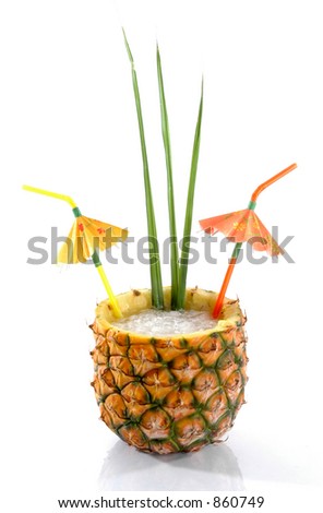 Natural Pineapple hollowed out and filled with an icy drink with tropical umbrellas and palm leaves isolated on a white background.