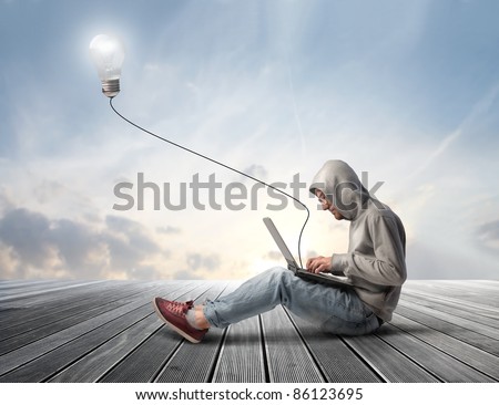 Man using a laptop with light bulb plugged in it