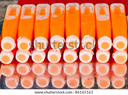 cool carrot juice bottles with shadow on metal plate