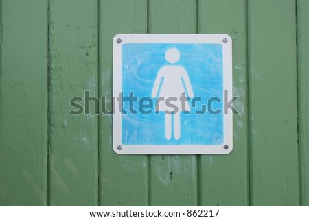 Weathered blue women's toilet sign on a green wooden door.