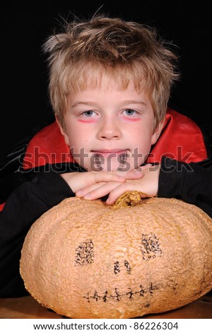 boy in halloween- outfit with pumpkin