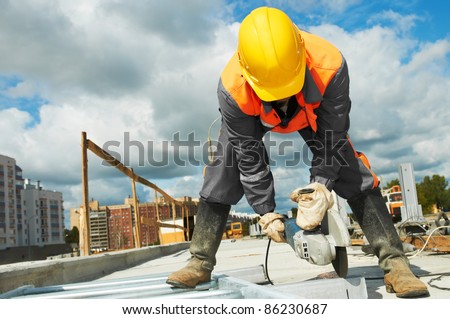 Builder worker with grinder machine cutting metal parts at construction site