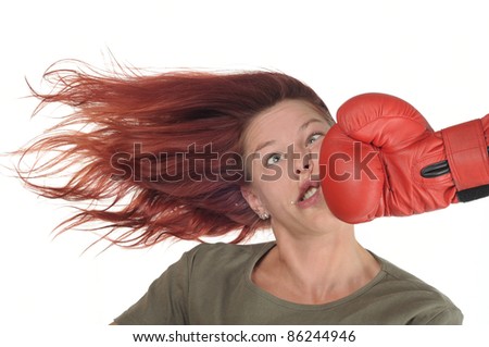 woman getting a hard punch from boxing glove fist Royalty-Free Stock Photo #86244946