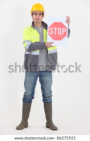 A road worker holding a stop sign.
