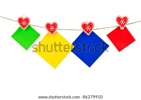 Color paper sheets on the rope attach to rope with decorative clothespins on white background