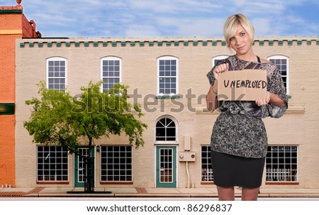 A beautiful young woman holding up an unemployment sign