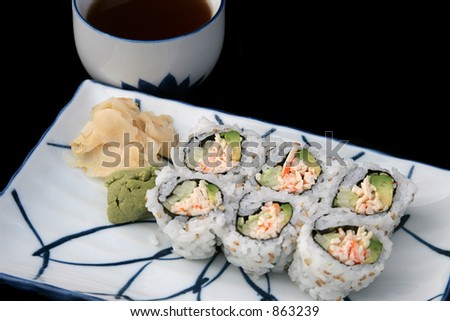 A sushi roll on Japanese plate, served with tea.