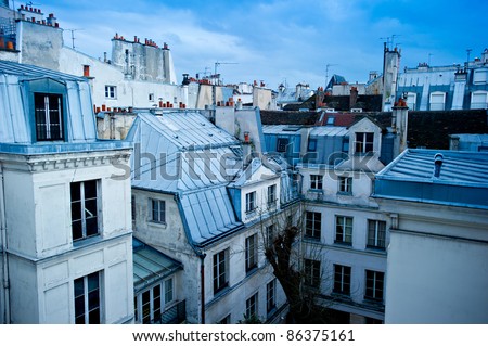 View of a Paris neighborhood skyline, featuring mostly rooftops from the top floor of an apartment building in Paris, France. Royalty-Free Stock Photo #86375161
