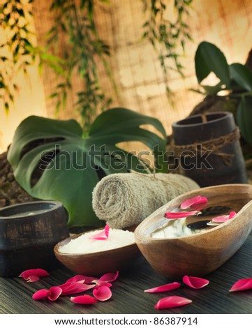 Natural spa setting with rose water and towel.