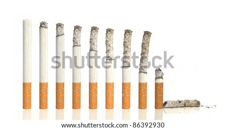 Burning cigarettes in a row on white background