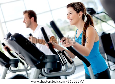 Group of people at the gym exercising on the xtrainer machines Royalty-Free Stock Photo #86502877
