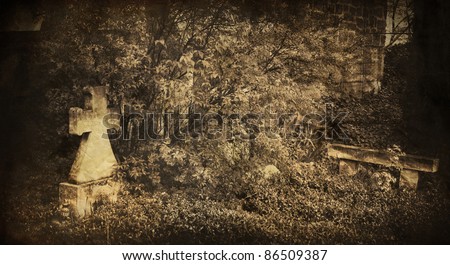 spooky vintage graveyard picture with cross in foreground