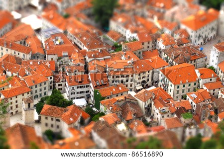 Tilt-shift miniature effect of bird eye view of buildings in Kotor old town, Montenegro Royalty-Free Stock Photo #86516890
