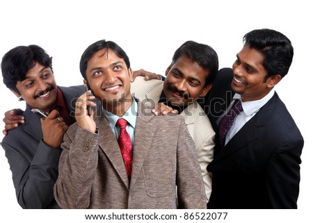 Indian young businessman talking in mobile others listening him.