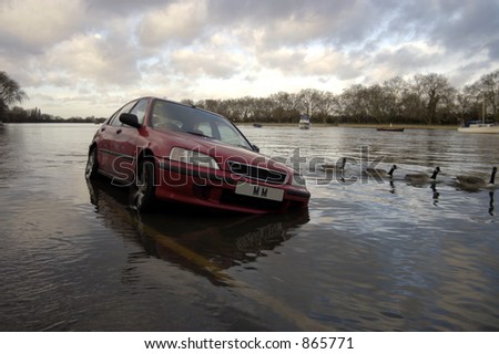 A car parked by the side of the road surrounded by water at high tide - faked plate Royalty-Free Stock Photo #865771