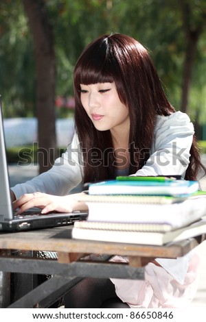 A smiling Asian student is studying.