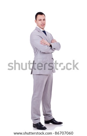 full body picture of a businessman with crossed hands standing against isolated white background