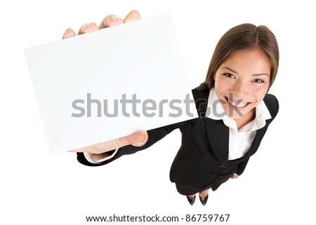 Showing sign - woman holding big business card / paper sign with copy space. Sign and businesswoman face both in focus. High angle full length view of happy smiling woman isolated on white background.