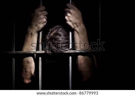 Hands of the prisoner on a steel lattice close up Royalty-Free Stock Photo #86779993