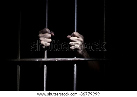 Hands of the prisoner on a steel lattice close up Royalty-Free Stock Photo #86779999