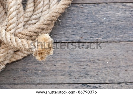 Big navy rope on wooden plank focusing on the end of the rope, can be use as background of powerpoint