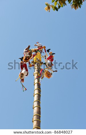 Papantla Flying Men in a clear blue sky of Xcaret Park Cancun, Mexico ancient Mayan Village on July 19, 2011 in Xcaret, Riviera Maya, Mexico