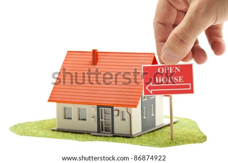 Hand holding "open house"-sign in front of model house - real estate concept