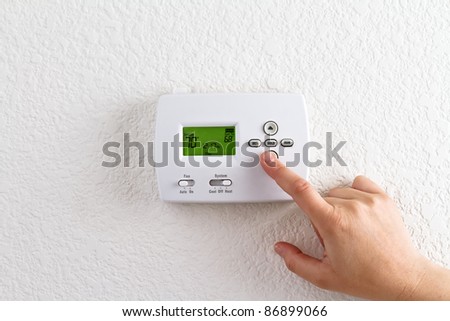 digital thermostat with finger pressing button Royalty-Free Stock Photo #86899066