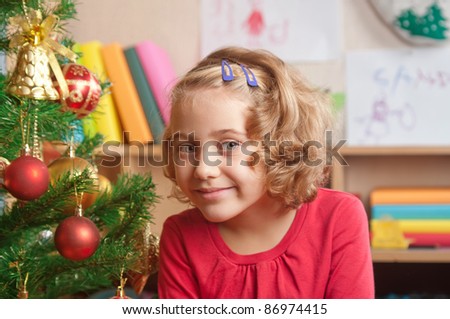 little girl at a Christmas fir-tree.