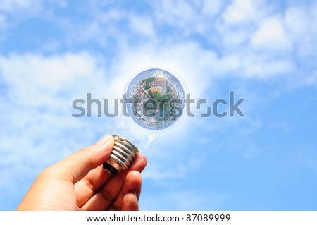 light bulb with earth globe in hand