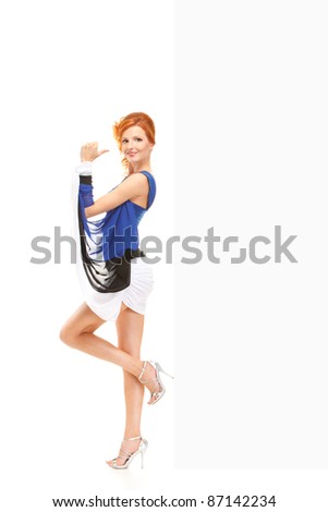 happy redhead girl wearing estonian flag dress showing blank billboard over white background