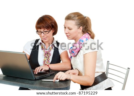 Two office girls looking at you over a laptop
