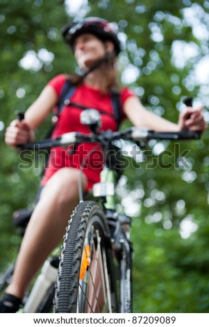 pretty young female biker outddors on her mountain bike (shallow DOF; selective focus)