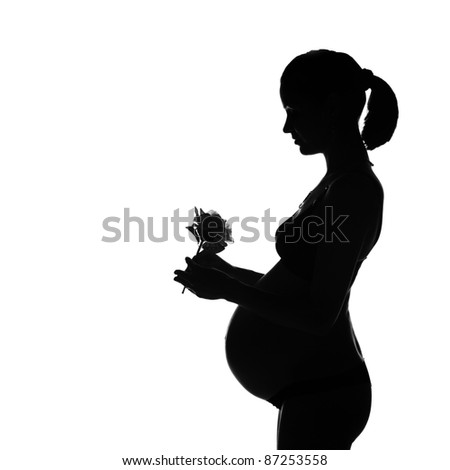 Silhouette of 33-weeks pregnant woman with rose flower