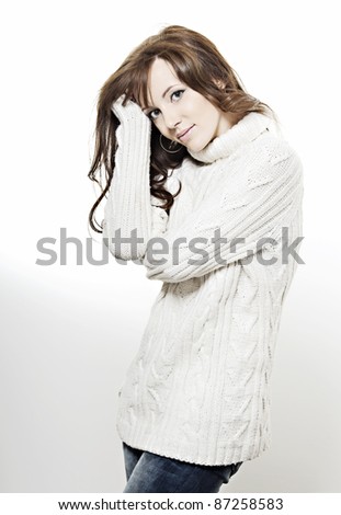 beautiful girl with perfect skin, long dark wavy hair, a white sweater on a white background