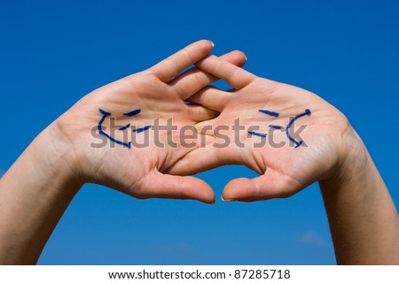Linked hands with smiles and sadness pattern against the blue sky