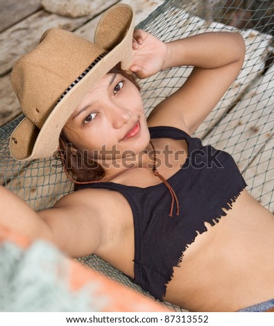 Young woman in cowboy hat resting on a hammock