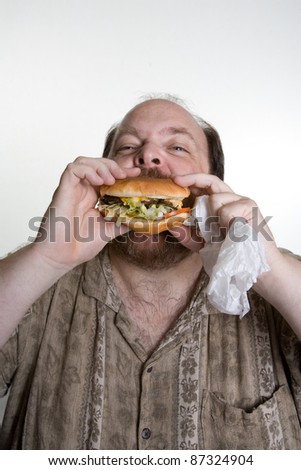 Overweight man in mid forties eating fast food