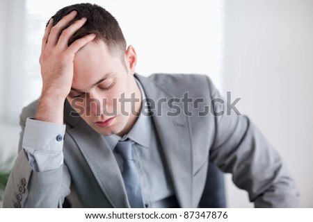 Close up of businessman after getting bad news sitting behind a table