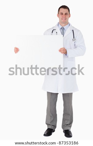 Standing doctor holding a sign to his right on white background